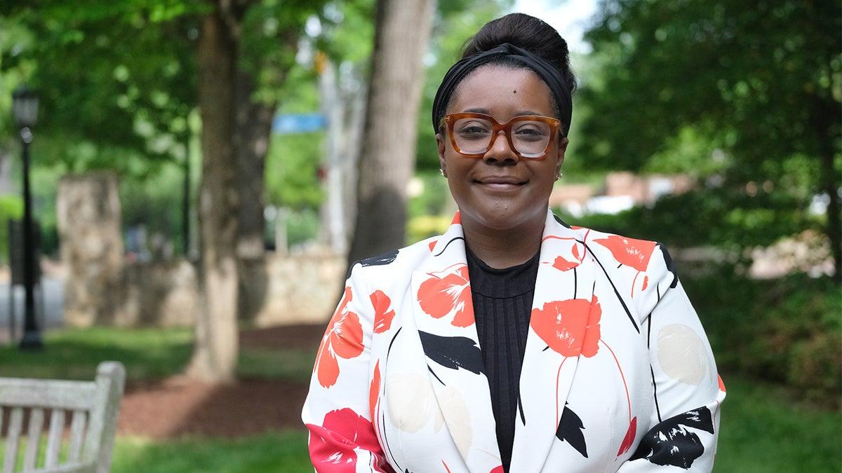 Constance Lindsay poses for a photo in front of the Davie Poplar tree on U.N.C. campus.